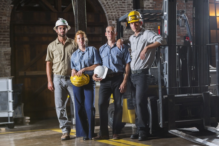 very beautiful construction crew posing with a forklift 