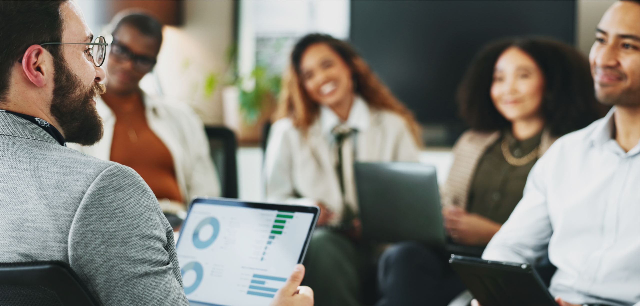 a marketing team sitting a desk smiling at each other