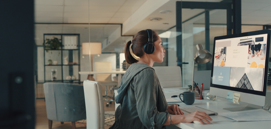 person with headphone sitting at a computer